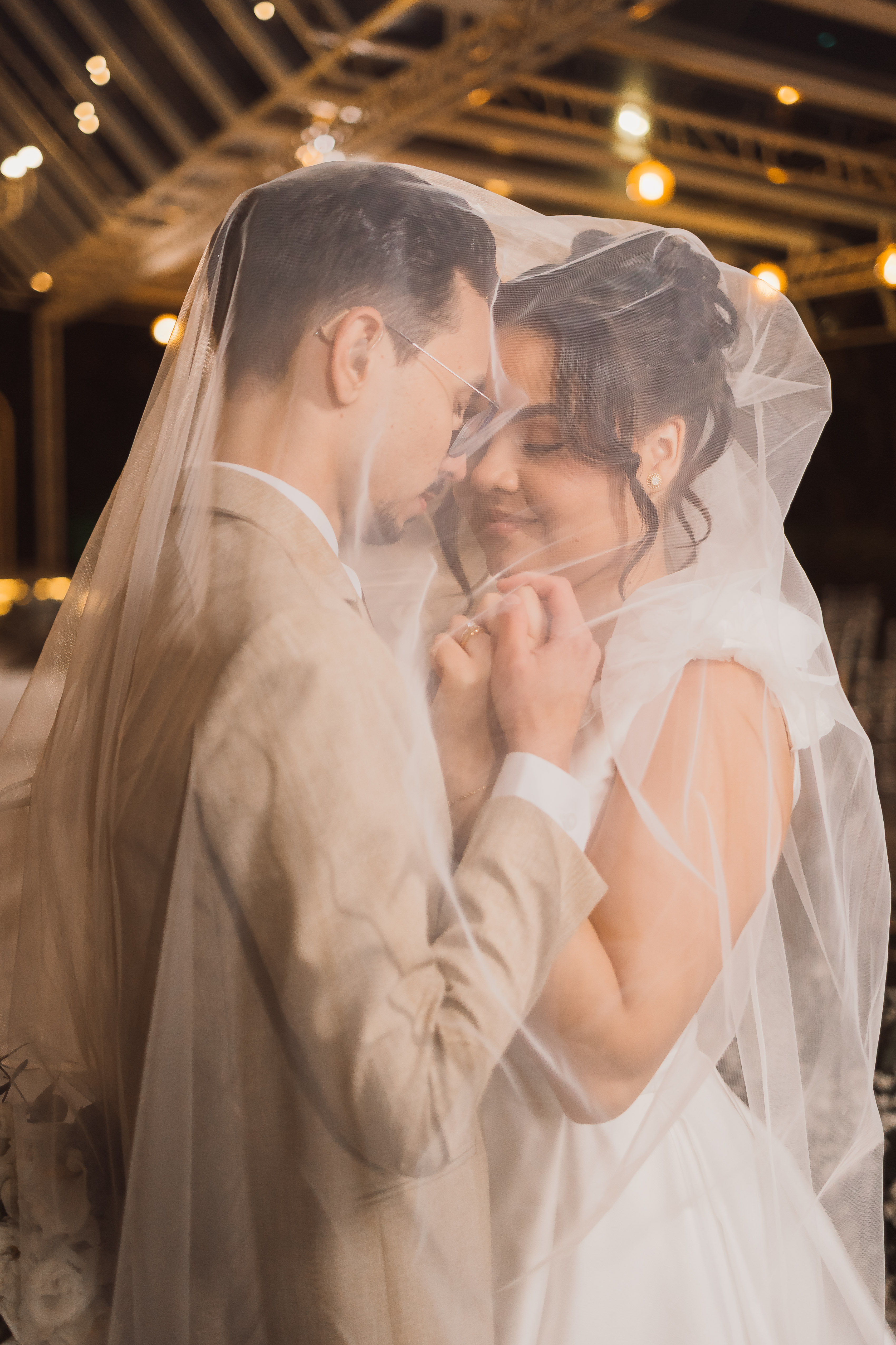 Casal dançando na festa de casamento sob luzes amarelas